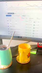 computer screen work desk with yellow and blue mugs